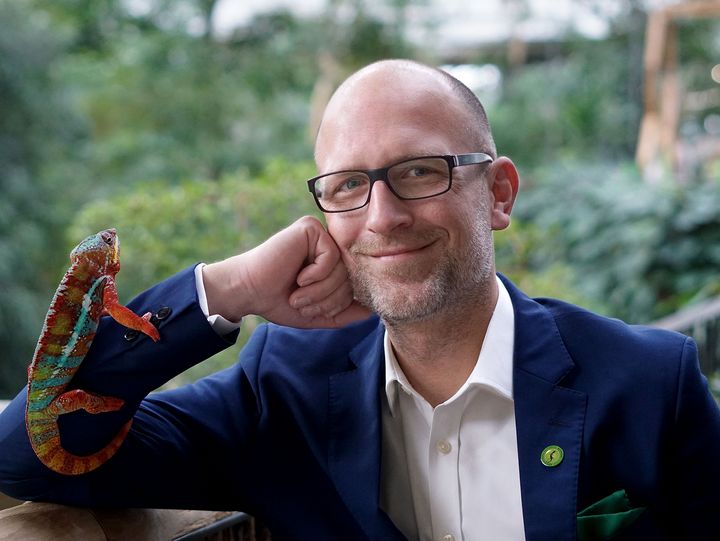 Sebastian Leifgen Geschäftsführer der ProPotsdam Naturerlebnis GmbH freundlich lächelnd und mit einem Chamäleon auf dem Arm