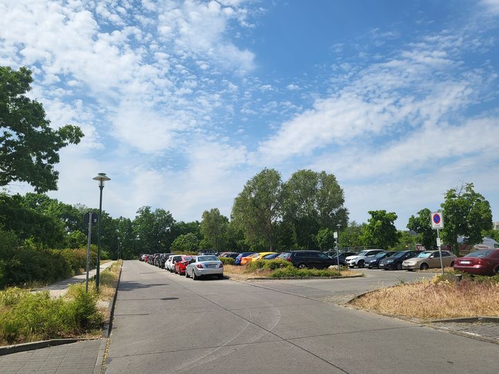 Straßenraum mit parkenden Autos, blauer Himmel