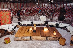 Der Innenraum einer Jurte im Nomadenland des Volksparks Potsdam mit Kissen, einem Fell und einem Tisch mit Kerzen